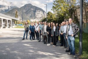 Kongressgäste posieren für ein Gruppenfoto vor der hollu Systemhygiene GmbH