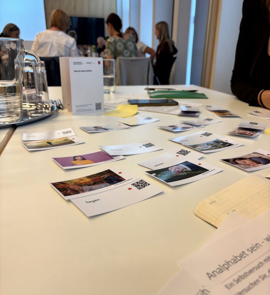Es liegen Karten mit verschiedenen Menschen in verschiedenen Positionen am Tisch. Es wurde die Aktivität zum Beispiel "liegen" der Fotokarte zugeordnet.