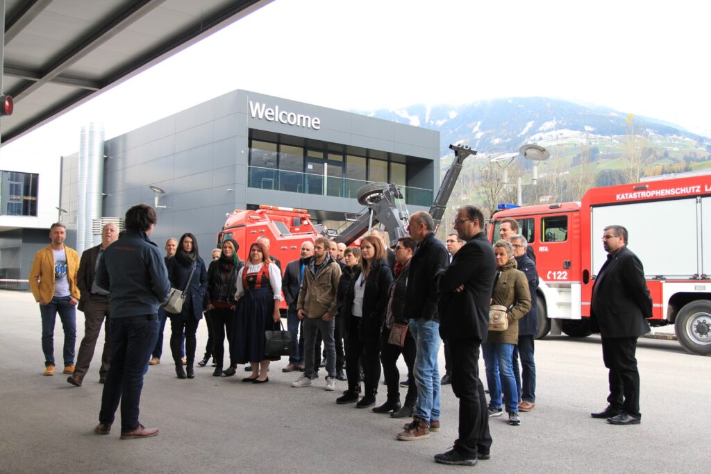 Bild von Kongressgästen bei der Betriebsführung, im Hintergrund Fahrzeuge und ein Gebäude der Firma EMPL