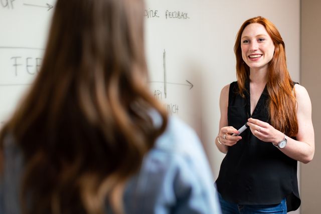 Zwei Frauen im Gespräch vor einem Whiteboard