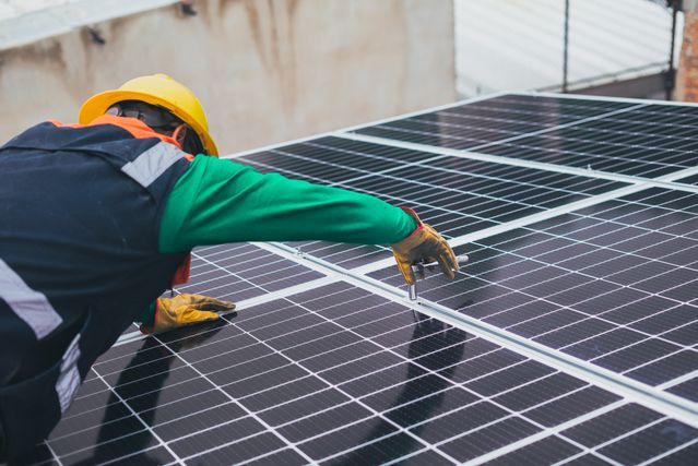 Person, die Photovoltaik-Anlage wartet