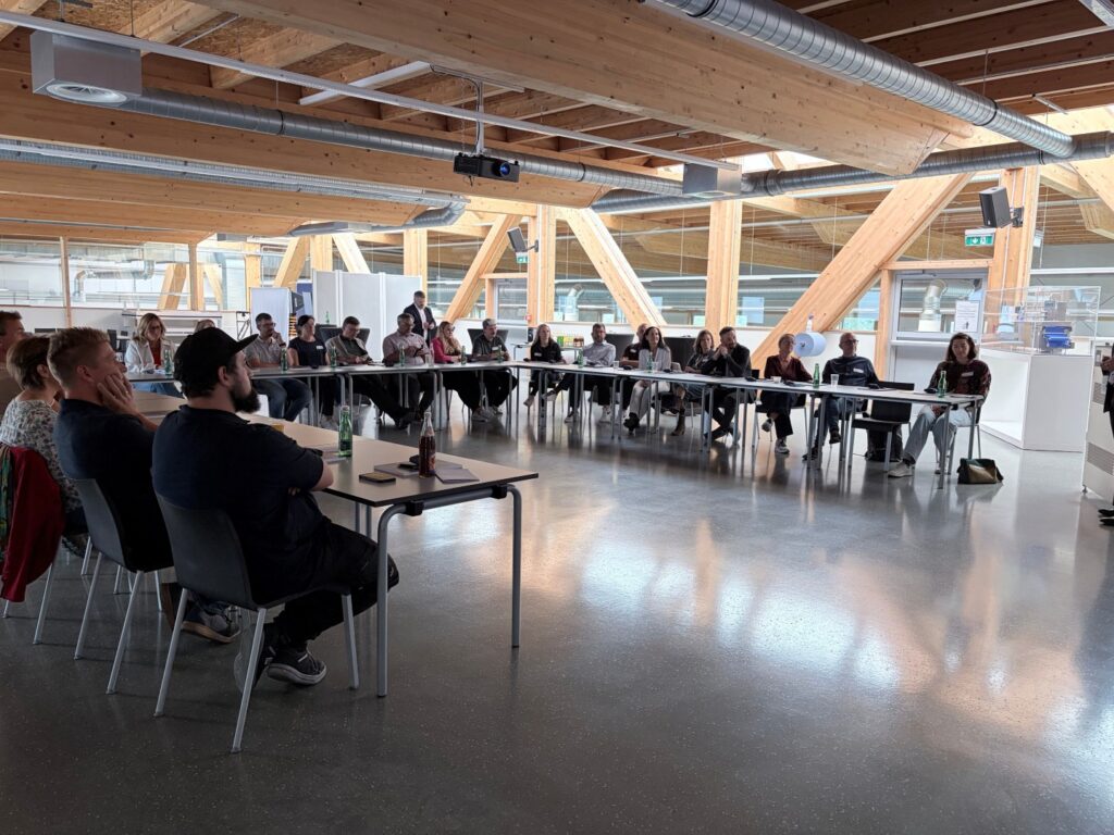 Die Besucher*innen am Stammtisch bei MULTIVAC an Tischen sitzend