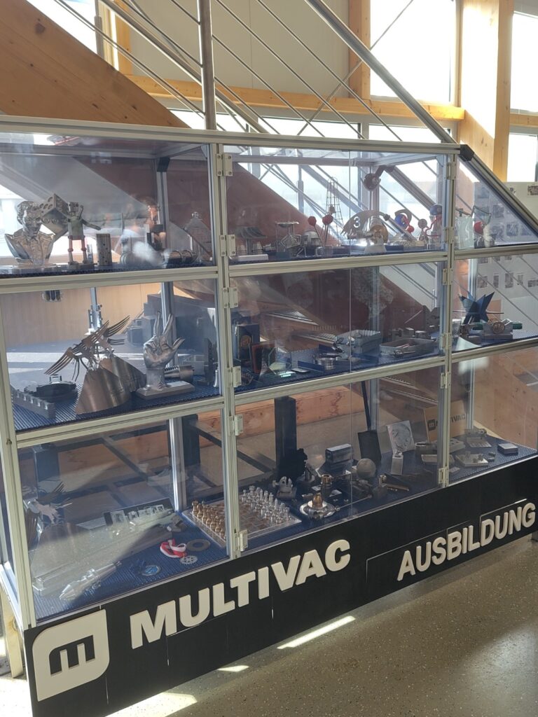 Blick auf eine Vitrine, die von Lehrlingen gefertigte Ausstellungsstücke enthält