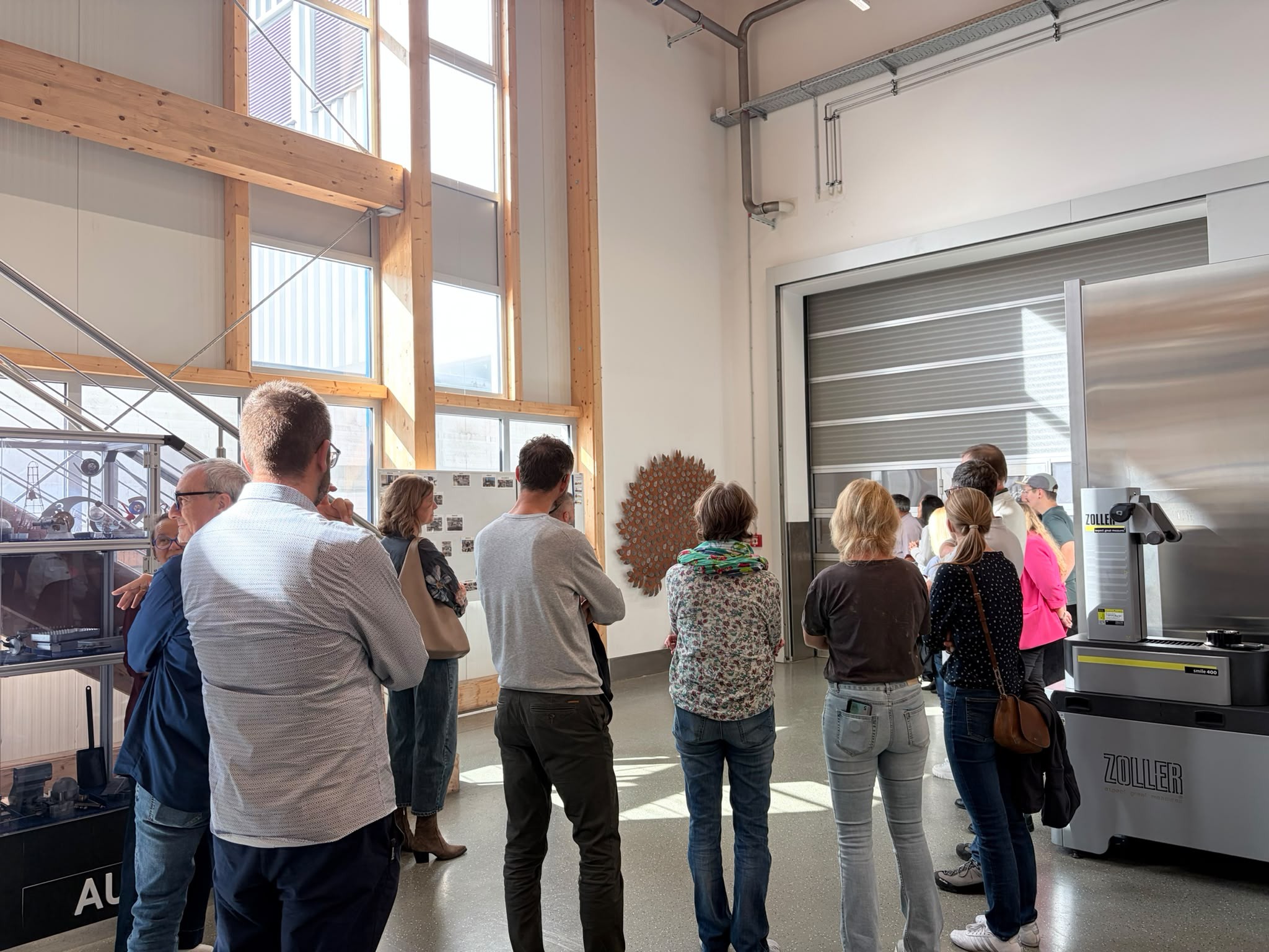 Betriebsführung durch das Ausbildungszentrum, im Hintergrund der eigens gefertigte Ausbildungsbaum aus Metall